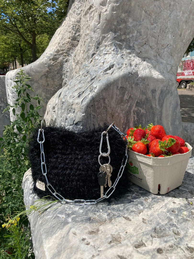 black fluffy crochet bag with a silver chain handle