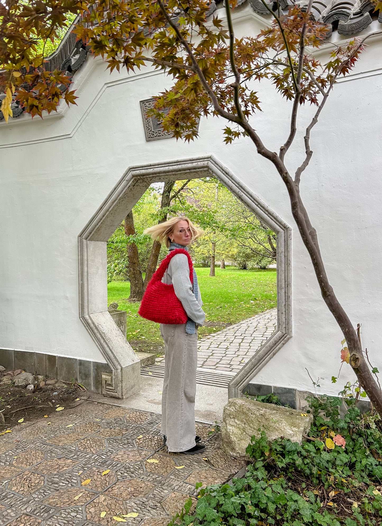 a person wearing a fluffy red crochet bag 