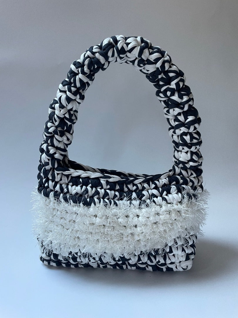 Black and white crochet bag with white fluffy detailing in the middle
