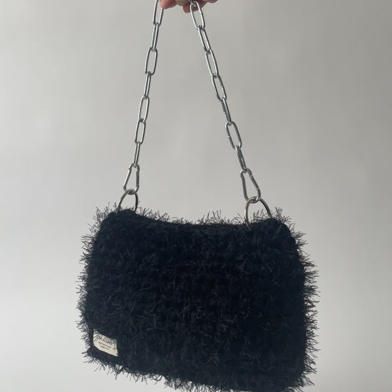 black fluffy crochet bag with a silver chain handle