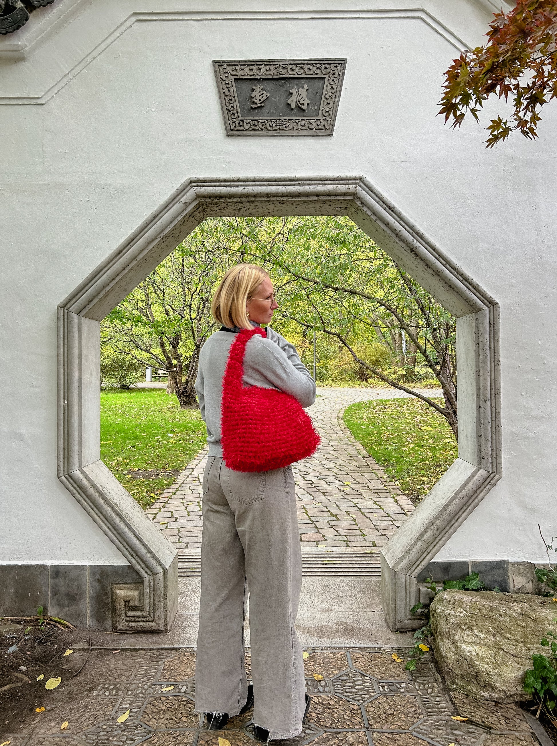 a person wearing a fluffy red crochet bag 